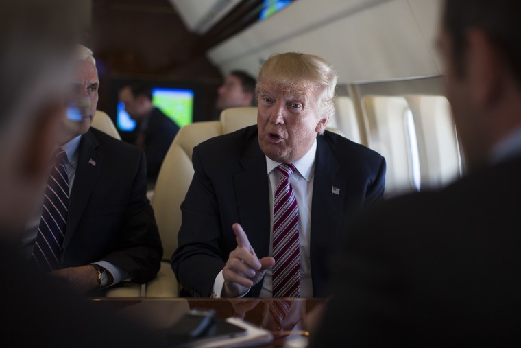 Republican presidential candidate Donald Trump talks with press on Sept. 5, 2016, aboard his campaign plane, while flying over Ohio, as Vice presidential candidate Gov. Mike Pence looks on. (Photo by Evan Vucci/AP)