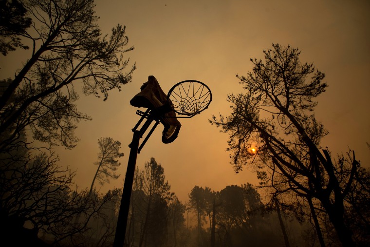 A melted basketball hoop is seen in a clearing after the Loma fire tore along a ridge top on Sept. 27, 2016 near Morgan Hill, Calif. (Photo by Noah Berger/AP)