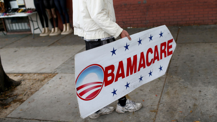 A man holds a sign directing people to an insurance company where they can sign up for the Affordable Care Act, also known as Obamacare in Miami, Fla in 2015. (Photo by Joe Raedle/Getty)