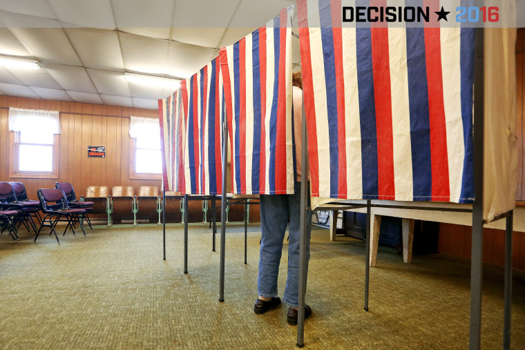 A voter casts a ballot behind a curtain at Smelser Town Hall, Nov. 8, 2016, in Georgetown, Wis. (Photo by Nicki Kohl/Telegraph Herald/AP)