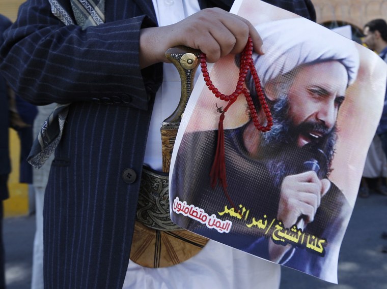 A Shi'ite protester carries a poster of Sheikh Nimr al-Nimr during a demonstration outside the Saudi embassy in Sanaa, Oct. 18, 2014. (Photo by Khaled Abdullah/Reuters)