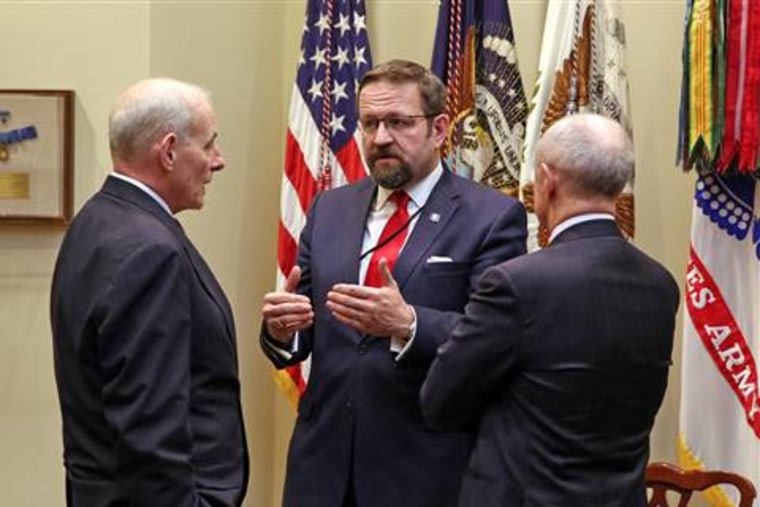Sebastian Gorka, center, talks with Homeland Security Secretary John F. Kelly, left, before a meeting with President Donald Trump on cyber security at the White House in January.&nbsp;