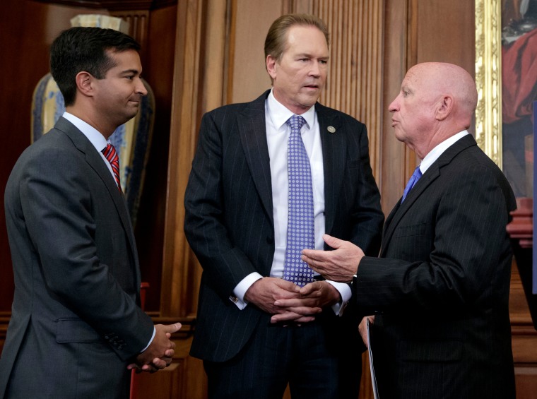 FILE - In this Sept. 27, 2017, file photo, from left, Rep. Carlos Curbelo, R-Fla., Rep. Vern Buchanan, R-Fla., and House Ways and Means Committee Chairman Kevin Brady, R-Texas, confer before a news conference at the Capitol in Washington.