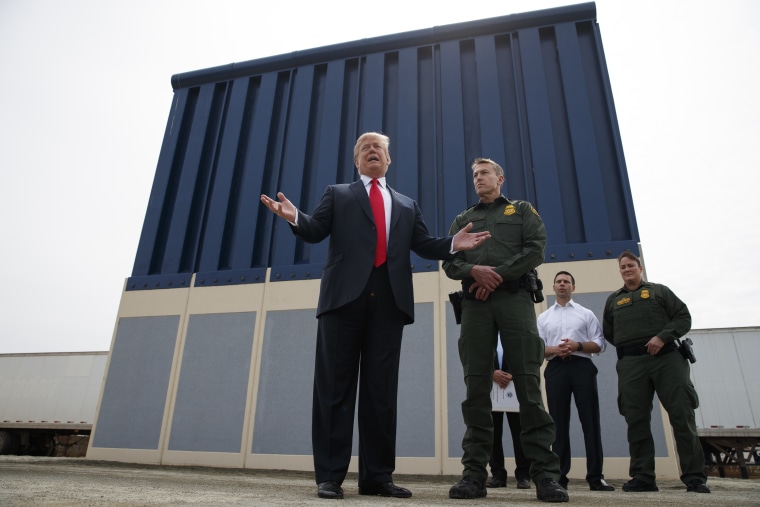 President Donald Trump talks with reporters as he reviews border wall prototypes, Tuesday, March 13, 2018, in San Diego.