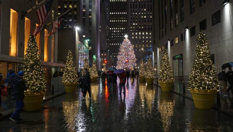 A rain-slicked Rockefeller Center at Christmas time.