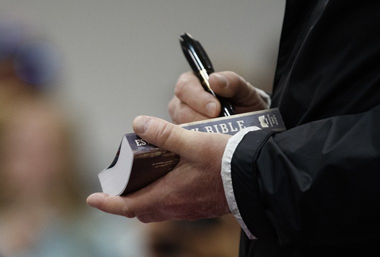 President Donald Trump signs a Bible as he greets people at Providence Baptist Church in Smiths Station, Ala., Friday, March 8, 2019, as they travel to tour areas where tornados killed 23 people in Lee County, Ala.