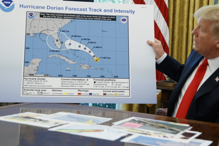 President Donald Trump holds a chart as he talks with reporters after receiving a briefing on Hurricane Dorian in the Oval Office of the White House, Wednesday, Sept. 4, 2019, in Washington.
