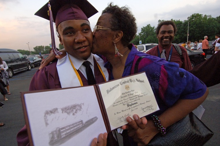 Alex Plair II, who will get free tuition for Western Michigan University, is congratulated by family friend Irene Ryan after his Kalamazoo Central High School graduation ceremony on Wednesday. Looking on is his father, Alex Plair.