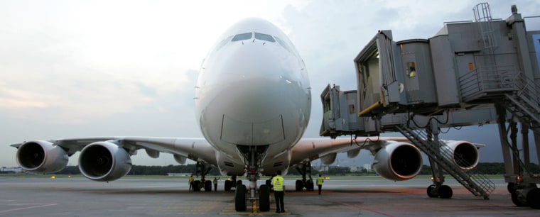 The first A380 waits at a Singapore Airlines terminal. Most of the places on the 471-seat double-decker plane were auctioned for charity on eBay, raising more than $1.25 million. The flight from Singapore to Australia is Thursday.