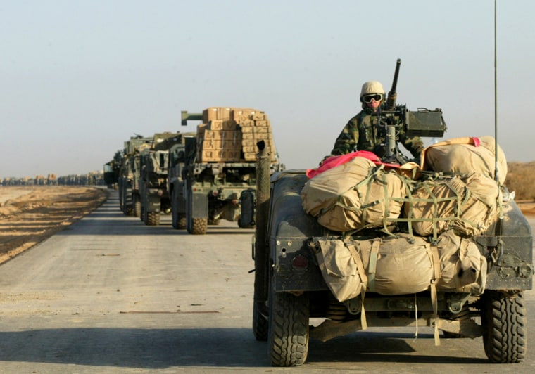 Image: A U.S. Marines vehicle guards the rear of a convoy of supplies trucks heading north on the road to Baghdad.
