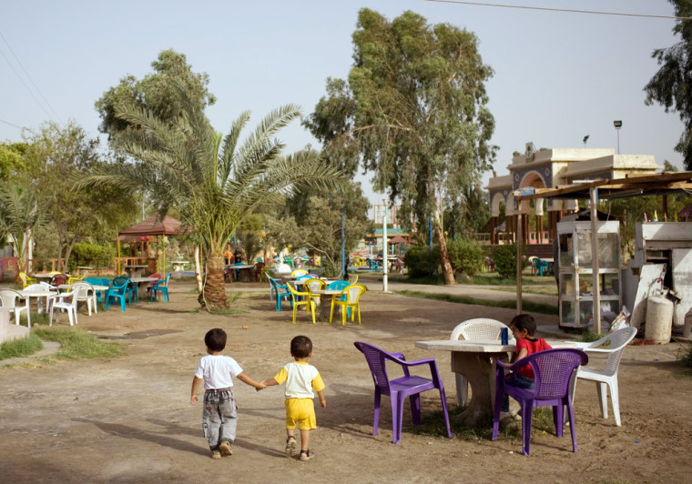 Image: Families picnic at a small neighborhood amusement park on their weekend in Basra