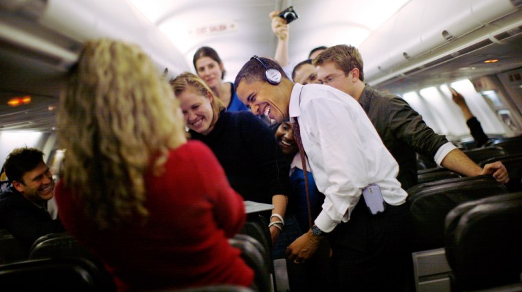 Image: Sen. Barack Obama watches a video with journalists on his plane.