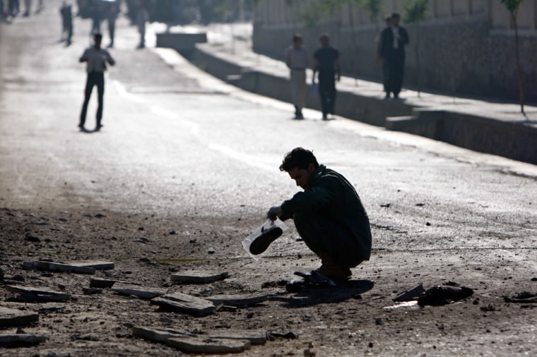A crime investigating team works at the site after a suicide bombing in Kabul