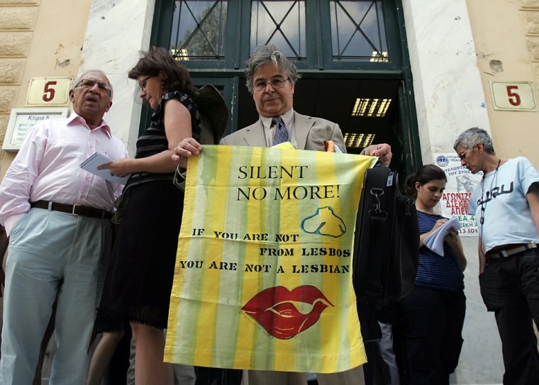 Image: Greek-American Paul Thymou, resident of the Aegean island of Lesbos, holds on June 10, 2008 a banner, reading: \"If you are not from Lesbos, you are not a Lesbian,\"