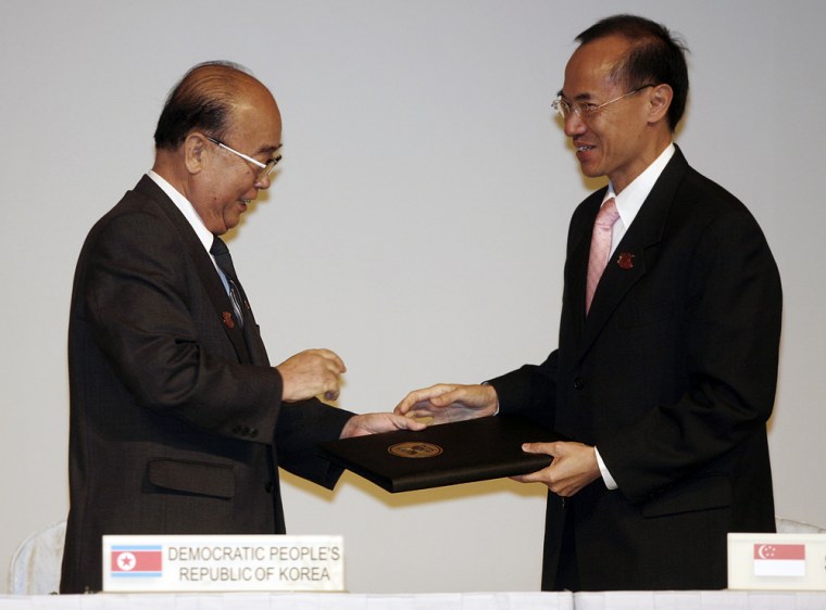 Image: North Korean Foreign Minister Pak Ui Chun, left, hands a document to Singapore's Foreign Minister George Yeo