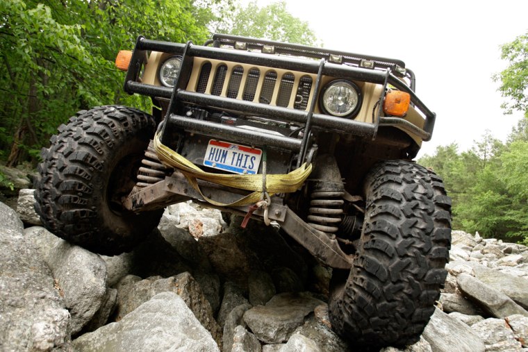 Image: John Andres drives his H1 Hummer over rocks at the Hummer Club's Straight Up or On The Rocks gathering