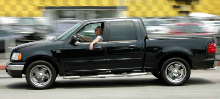 Image: A man in a full-size Ford F-150 pickup truck
