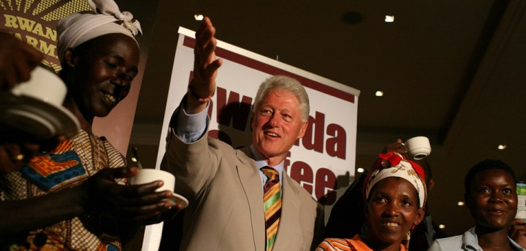 Image: Former U.S. President Bill Clinton smiles as he meets with local coffee growers at the Kigali Serena Hotel