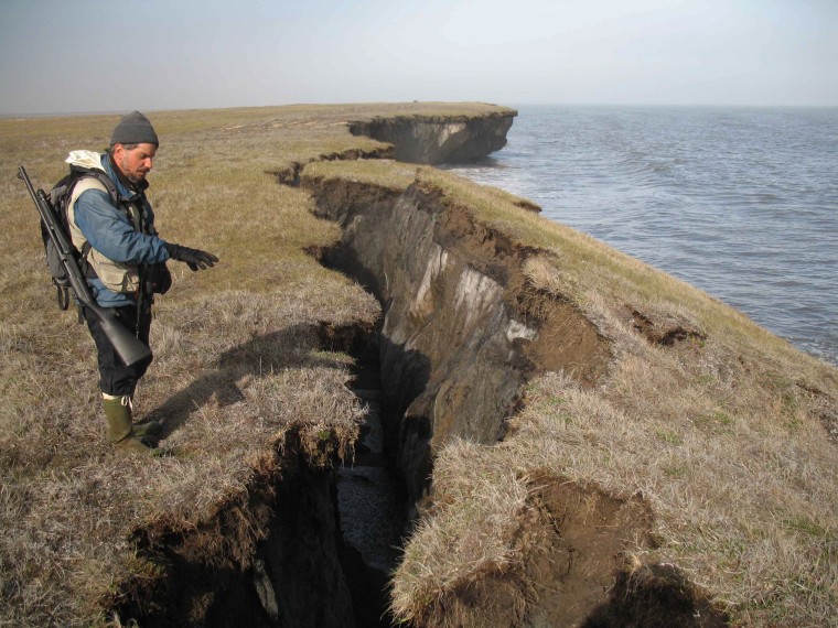 A scientist shows erosion along the shore of the Beaufort Sea.
