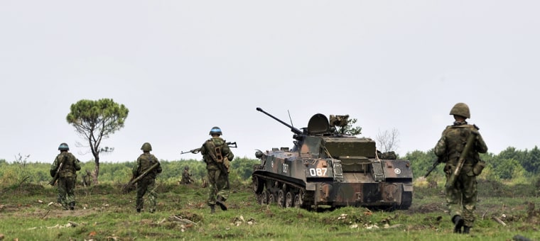 Image: Russian troops move across open ground during a search operation outside of the Black Sea port of Poti, Georgia