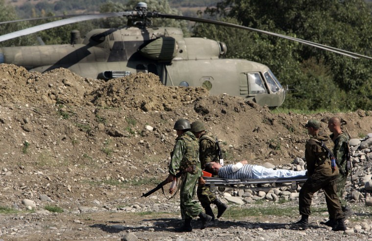 Image: A wounded Russian pilot is carried to a helicopter following prisoners swap in Igoeti, Georgia
