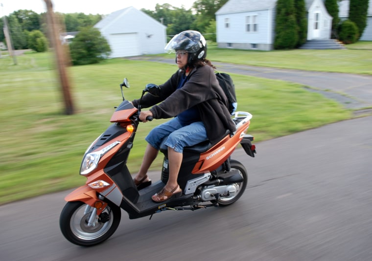 Image: Barbara Kennebeck rides her scooter to save on gas costs