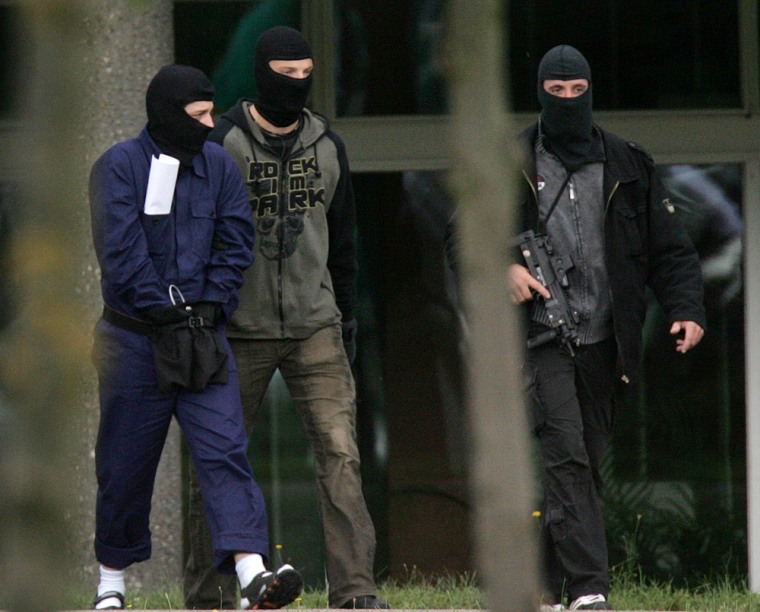 Image: one of three terror suspects is seen being led away
