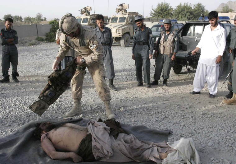 Image:A Canadian soldier with the International Security Assistance Force looks at the body of a suspected Taliban