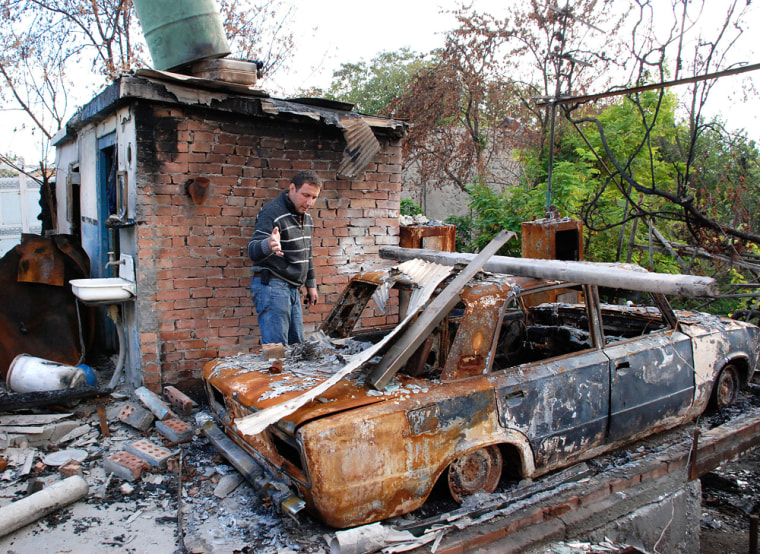Image: A Georgian man examines his burnt property