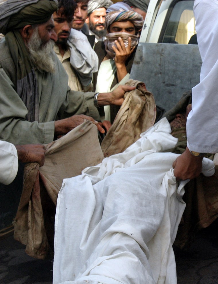 Image: Afghans load a body of a Taliban militant killed by Afghan and NATO-led forces, onto a vehicle at a hospital in Lashkar Gah