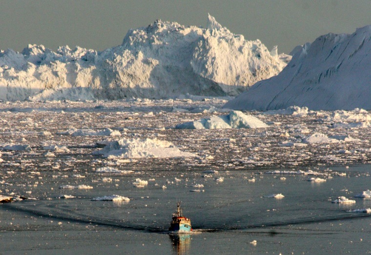 Image: A boat skims through the melting ice