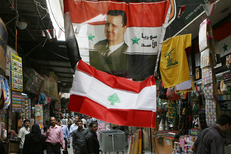Image: A picture of Syrian President Bashar Assad is printed on a Syrian flag
