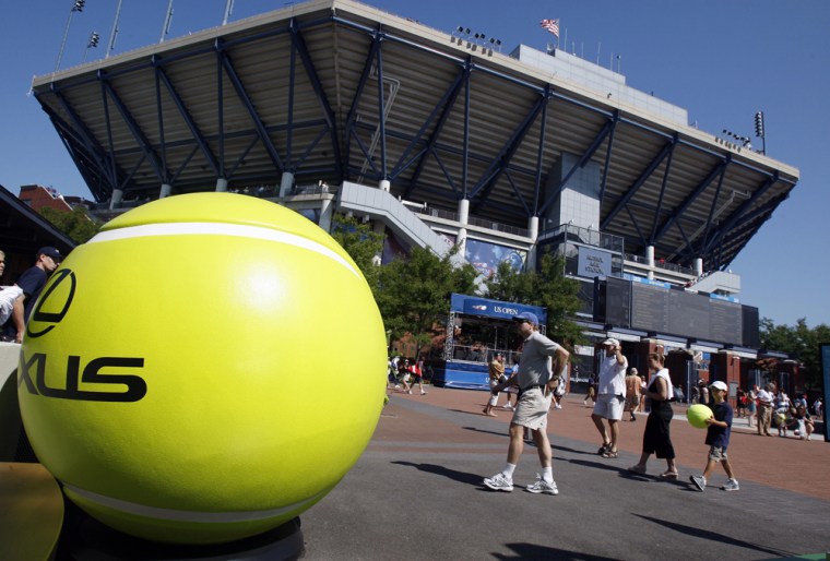Image: Fans walk past a giant tennis ball outside the Arthur Ashe Stadium