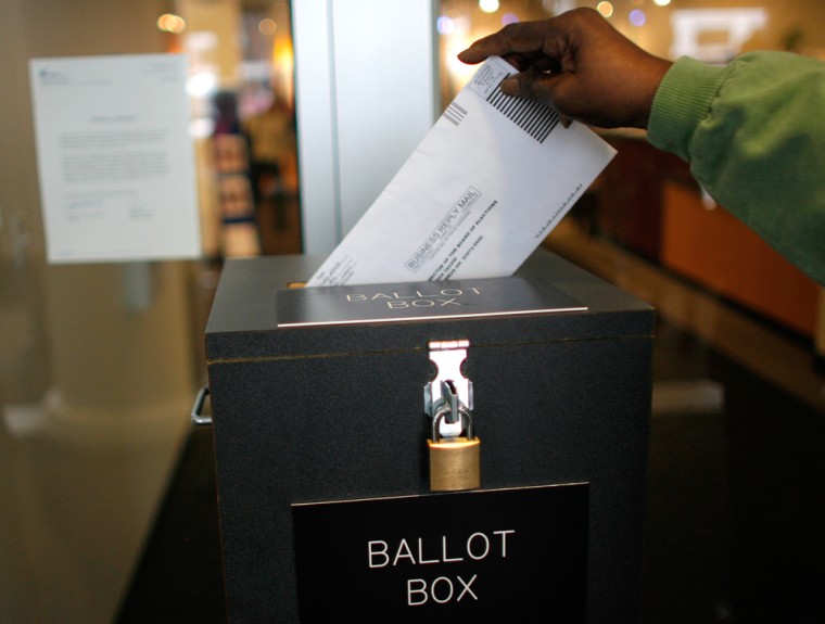 Image: A voter drops off an absentee ballot
