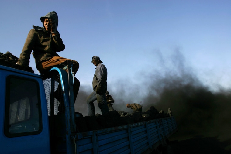 Chinese coal workers load  coal on to a truck  in Baotou, nestled in the sand-sculpted ravines of Inner Mongolia, China, Tuesday, May 8, 2007. (AP Photo/Elizabeth Dalziel)