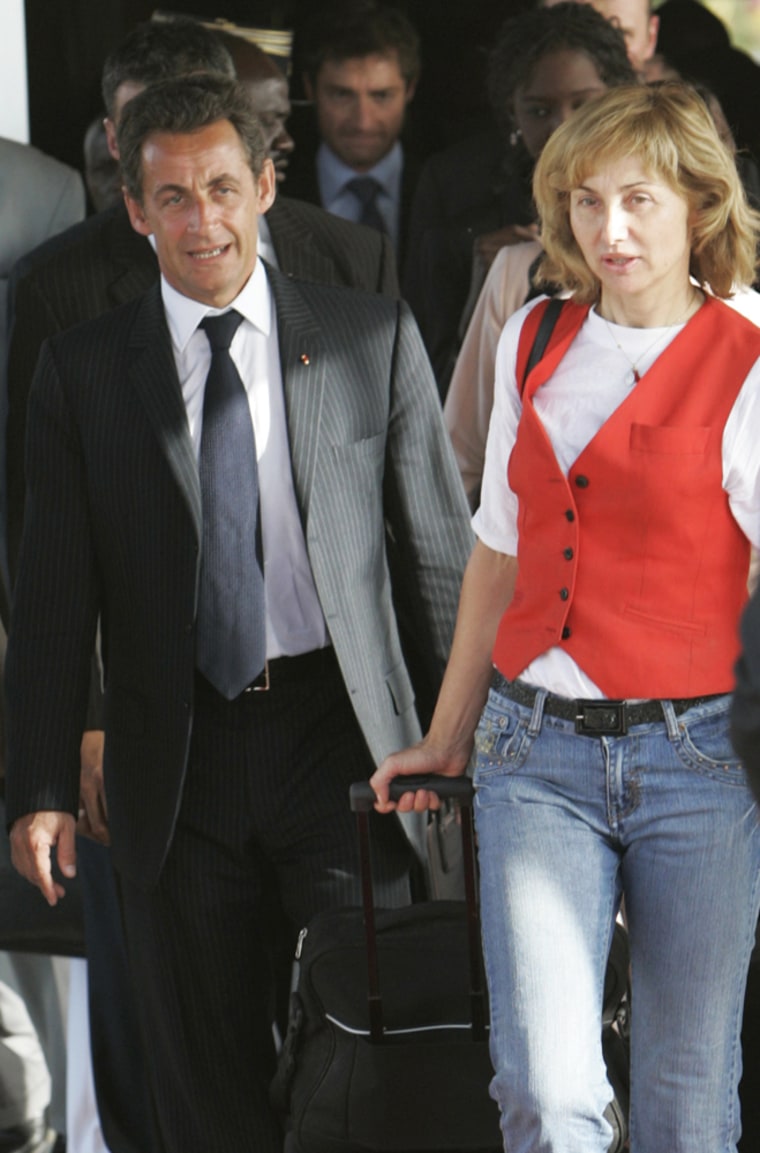 French President Nicolas Sarkozy, left, walks behind a Spanish air hostess after she and others were freed on Sunday in the Chad capital, N'Djamena.