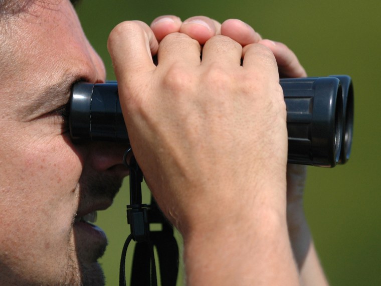 Image: Man looking through binoculars