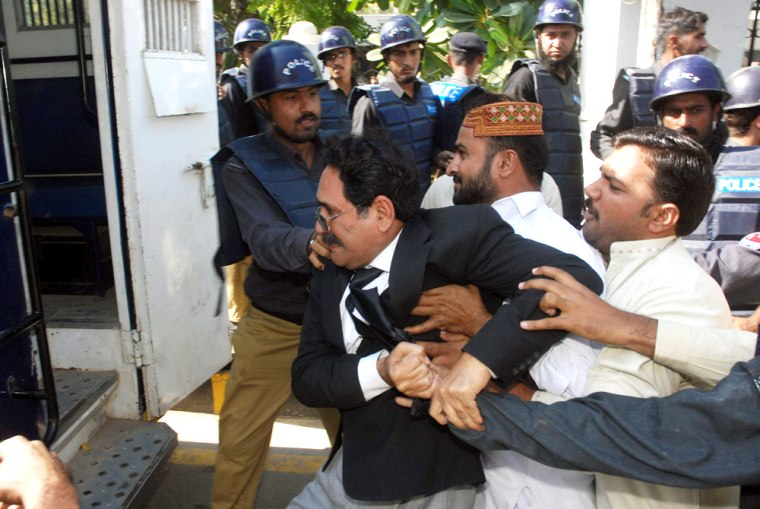 Uniformed and plain-clothed police officers push a lawyer into a police van in Multan, Pakistan, on Tuesday.