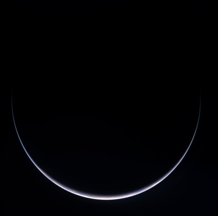 A sun-illuminated crescent can be seen around Antarctica in this image taken by Rosetta during its flyby on Nov. 13. The image is a color composite combining images obtained at various wavelengths.