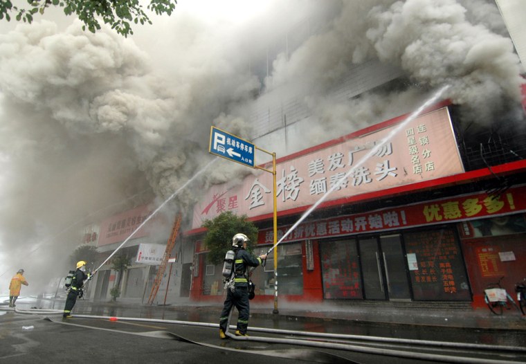 Firefighters battle a blaze at a 28-story building in the eastern commercial city of Wenzhou, China, on Wednesday.