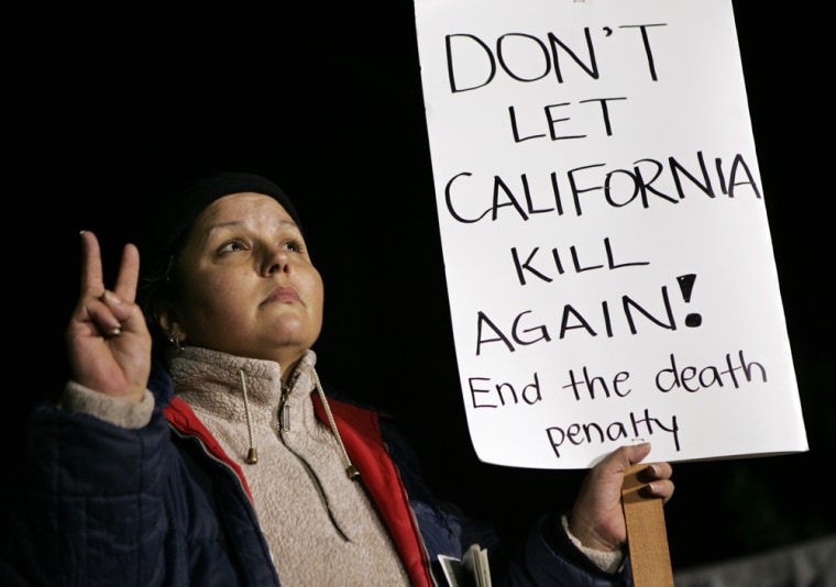 Image: Death penalty opponent Linda Avalos gives the peace sign as she holds a sign in front of San Quentin Prison in San Quentin, Calif.