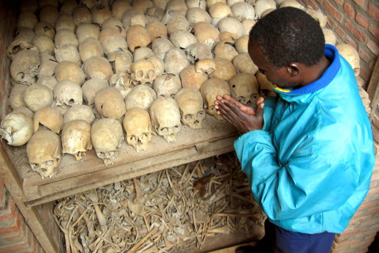 Image: A Rwandan survivor of the 1994  Genocide prays over the bones of genocide victims at a mass grave in Nyamata, Rwanda