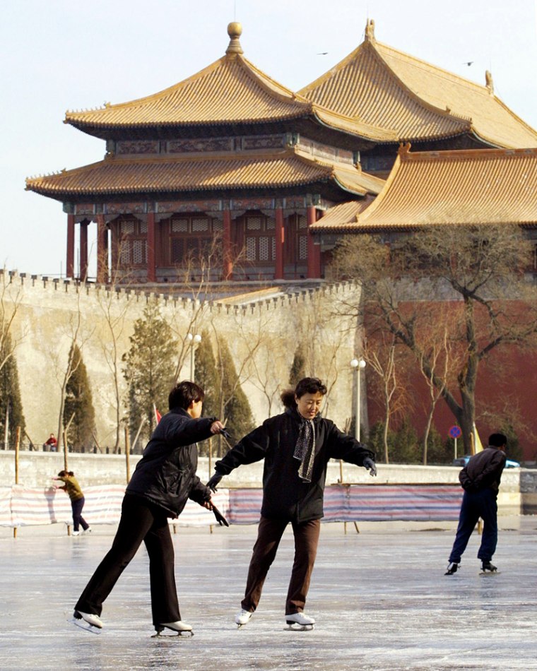 ** FOR IMMEDIATE RELEASE ** ** FILE ** Chinese skate on the frozen moat which surrounds Beijing's Forbidden City, as one of the corner towers of the former imperial palace looms behind in this Jan. 30, 2002 file photo. (AP Photo/Greg Baker,File)