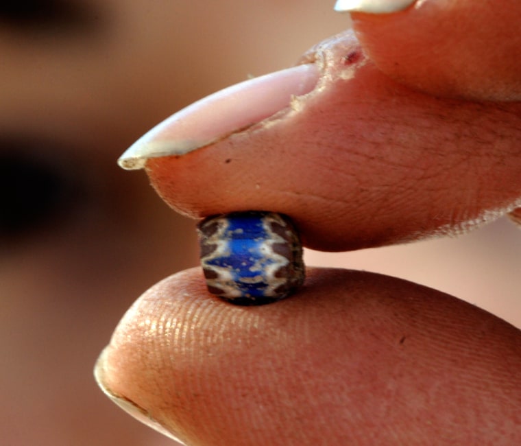 Image: Archaeologist Rachel Vykukal, 24, holds a glass bead