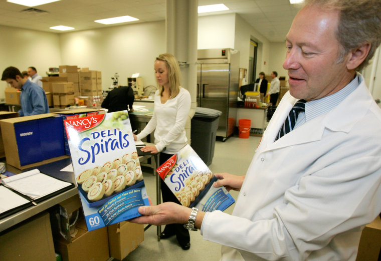 Image: Vice President of Innovation and Quality James Matthews shows some of the packaging at the Heinz Global Innovation and Quality Center