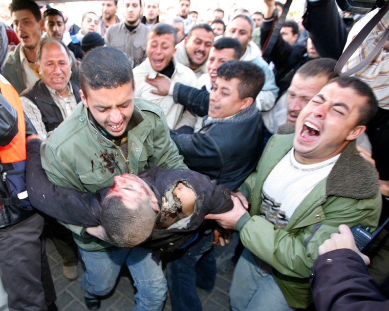 Image: People carry the body of a Palestinian after he was killed by Israeli troops during a raid in Gaza.