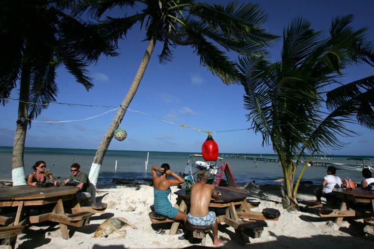 Image: tourists relax at an outdoor bar on Caulker Caye, Belize