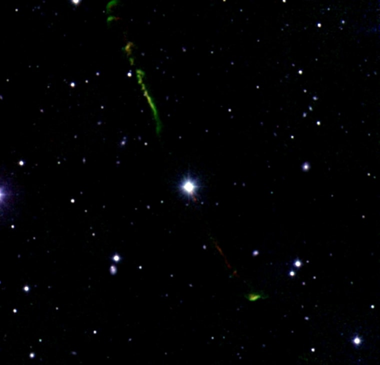 The star BP Piscium (center), in the constellation Pisces, is shooting out jets of gas (green and red streaks).
