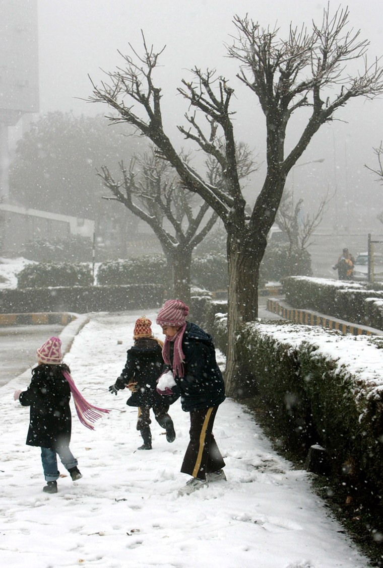 Children play in the snow in Amman