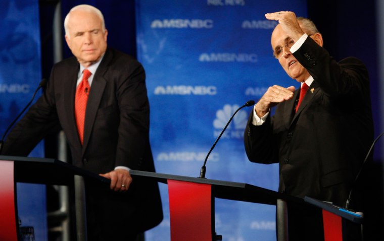 Image: US Senator John McCain listens as former New York City Mayor Giuliani speaks during GOP debate at Florida.